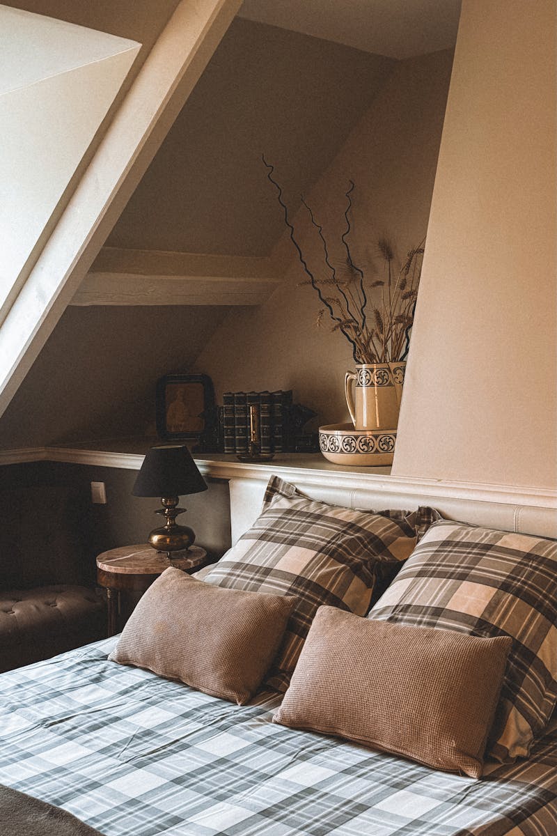 Inviting attic bedroom with boho style decor and plaid bedding in Andorra.