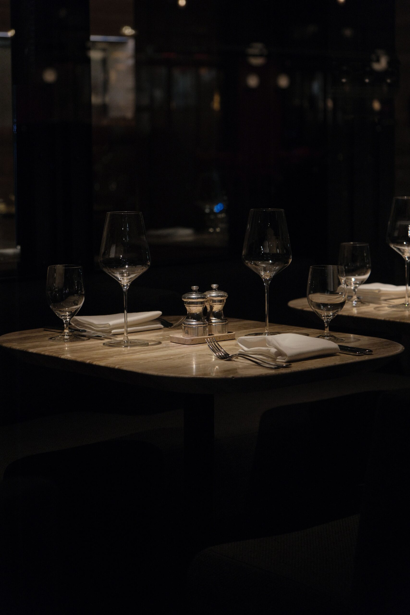 Sophisticated table setup in a New York restaurant, with wine glasses and cutlery, ready for a gourmet experience.